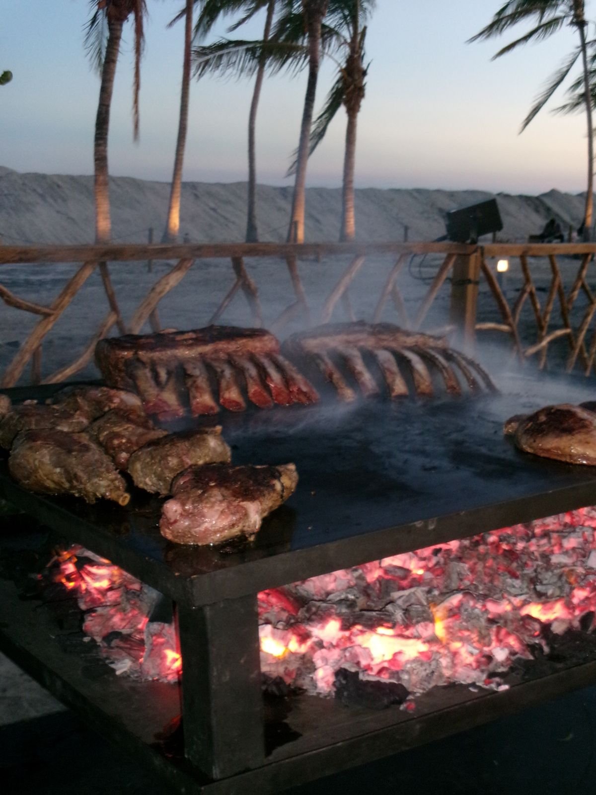 Costillares sobre brasas al atardecer